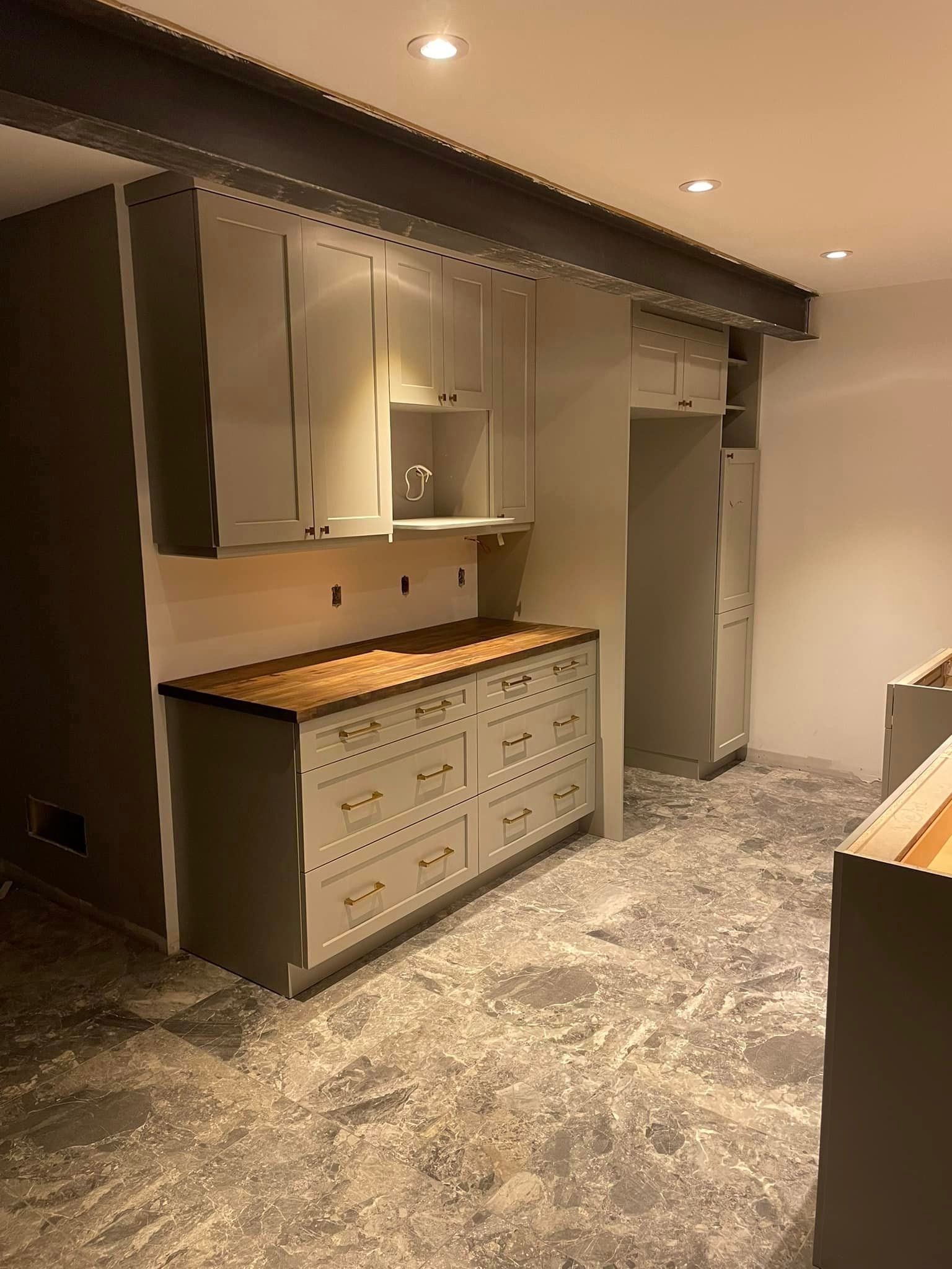 A kitchen with white cabinets and a granite counter top.