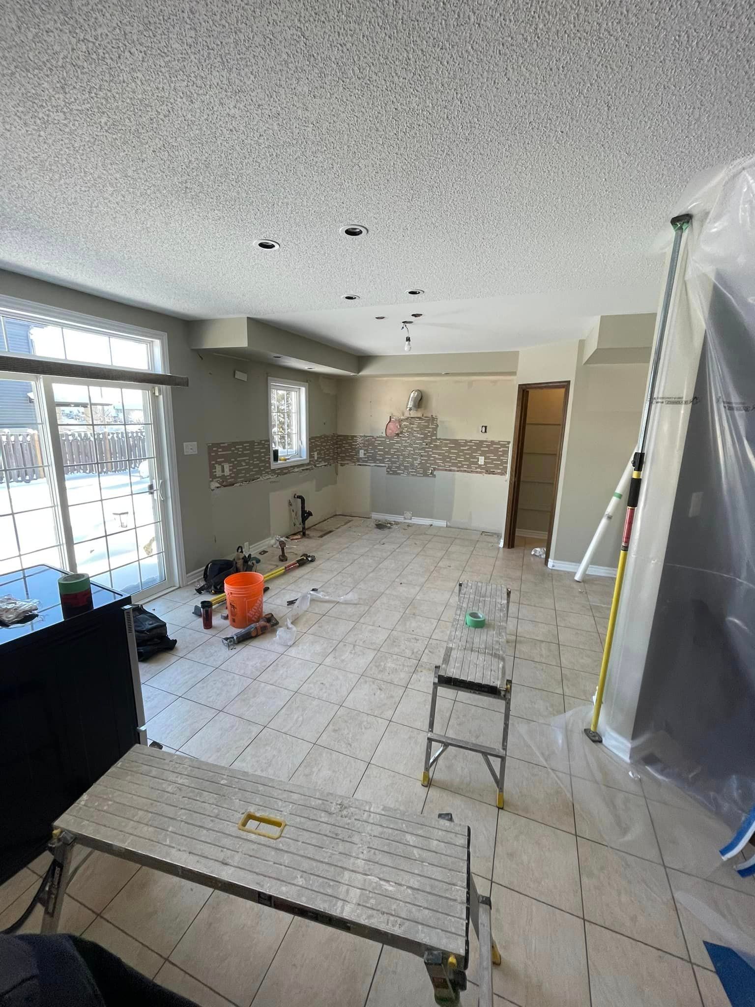 A living room is being remodeled with tile floors and a ladder.