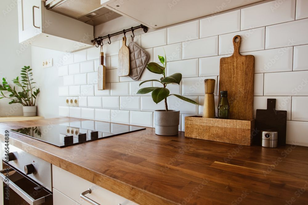 A kitchen with a wooden counter top and white tiles.