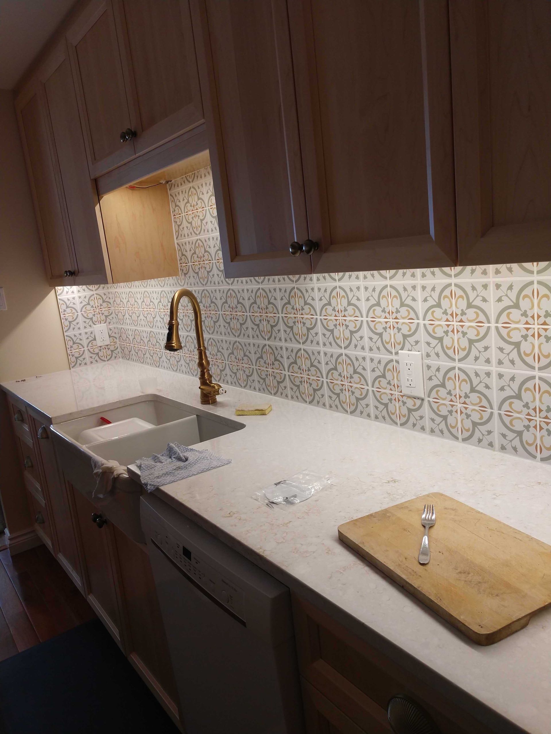 A kitchen with a sink and a cutting board on the counter.