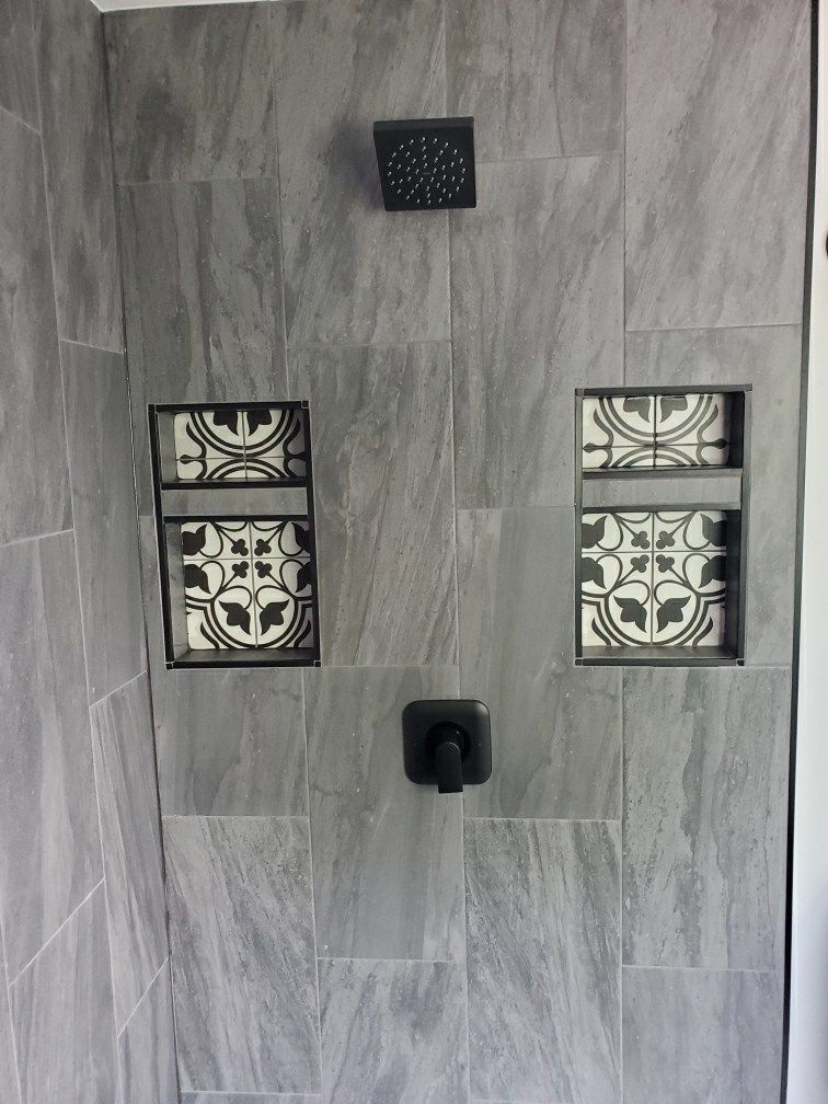 A shower with two niches and a shower head.
