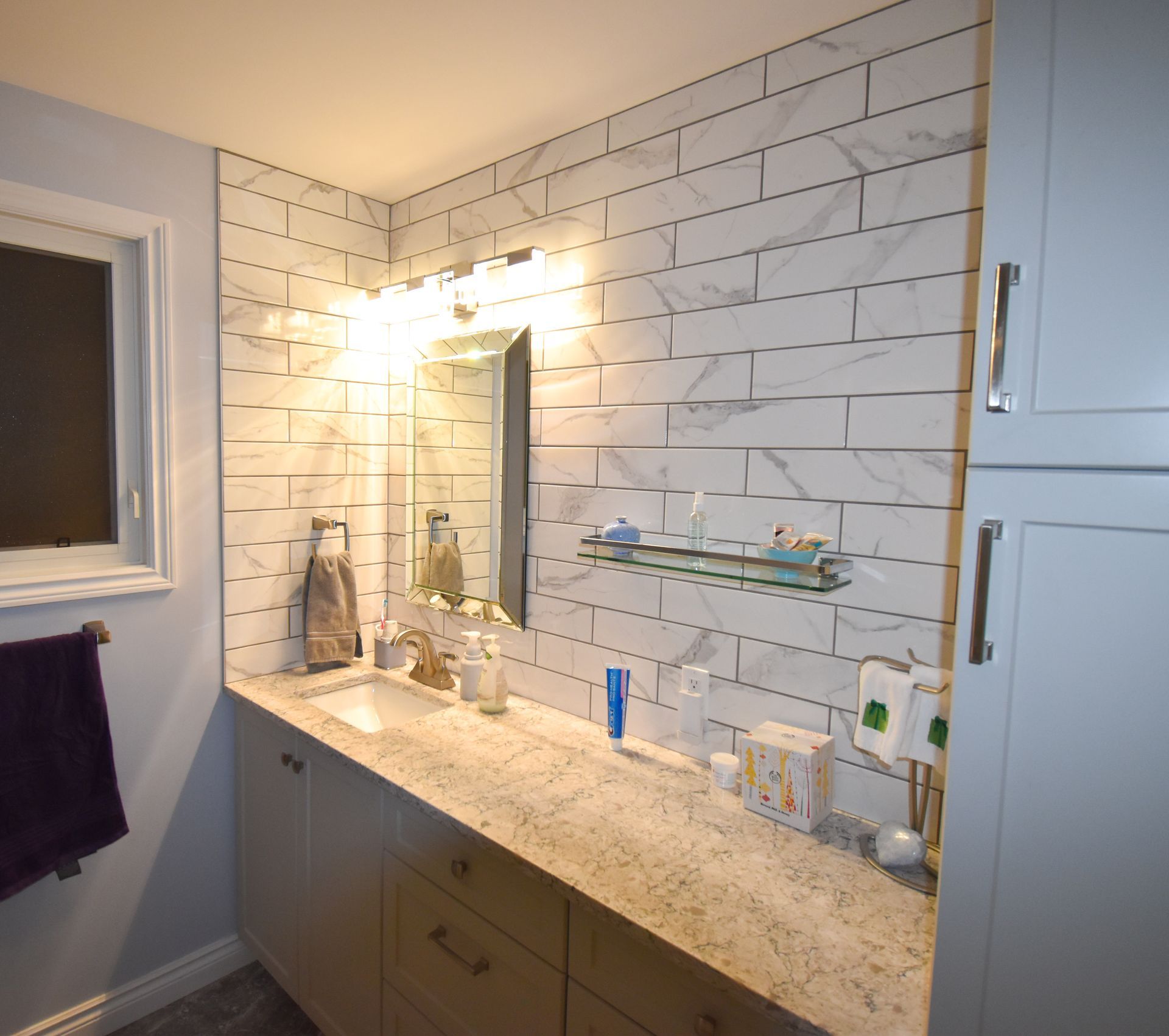A bathroom with a sink , mirror and shower.