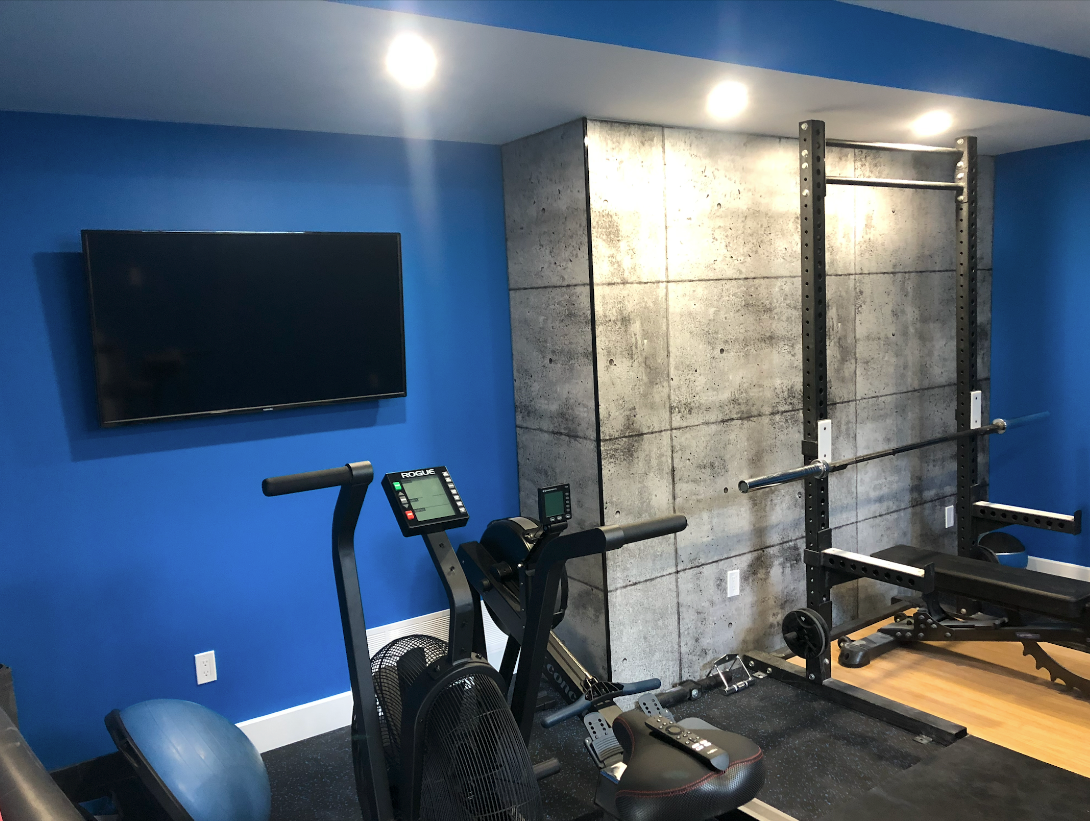 A gym with blue walls and a flat screen tv.