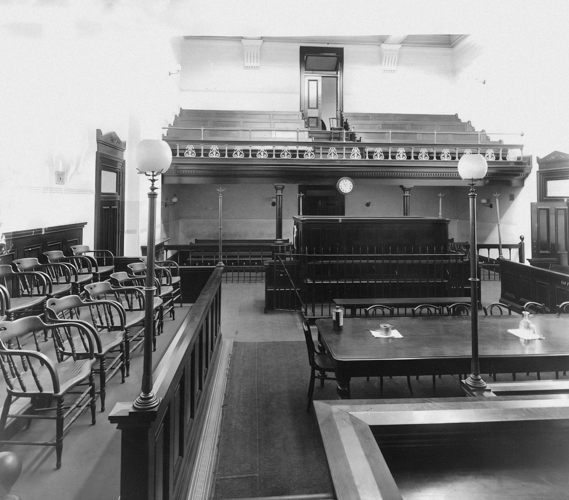 A black and white photo of a room with tables and chairs