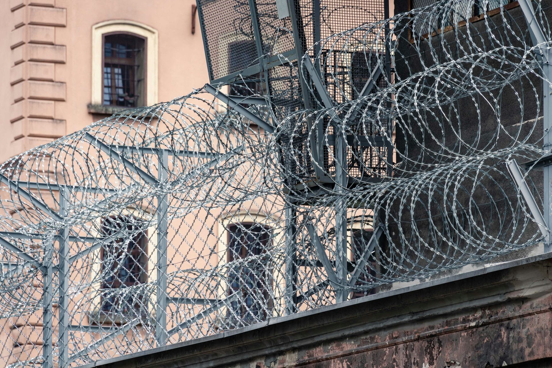 A barbed wire fence is surrounding a building.