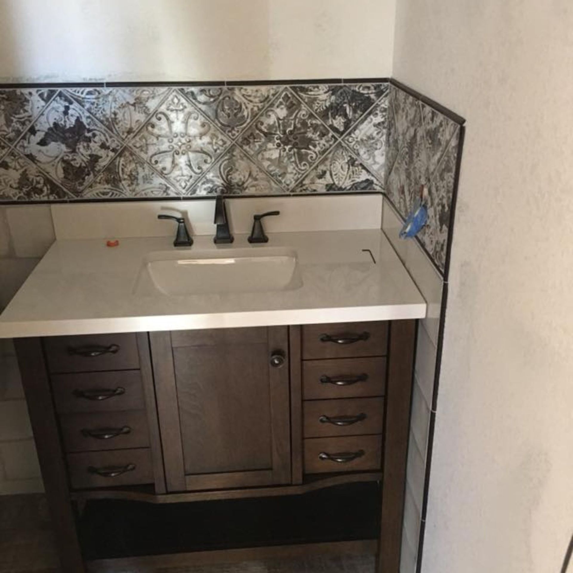 Masters Touch Roofing - A bathroom vanity with a sink and drawers