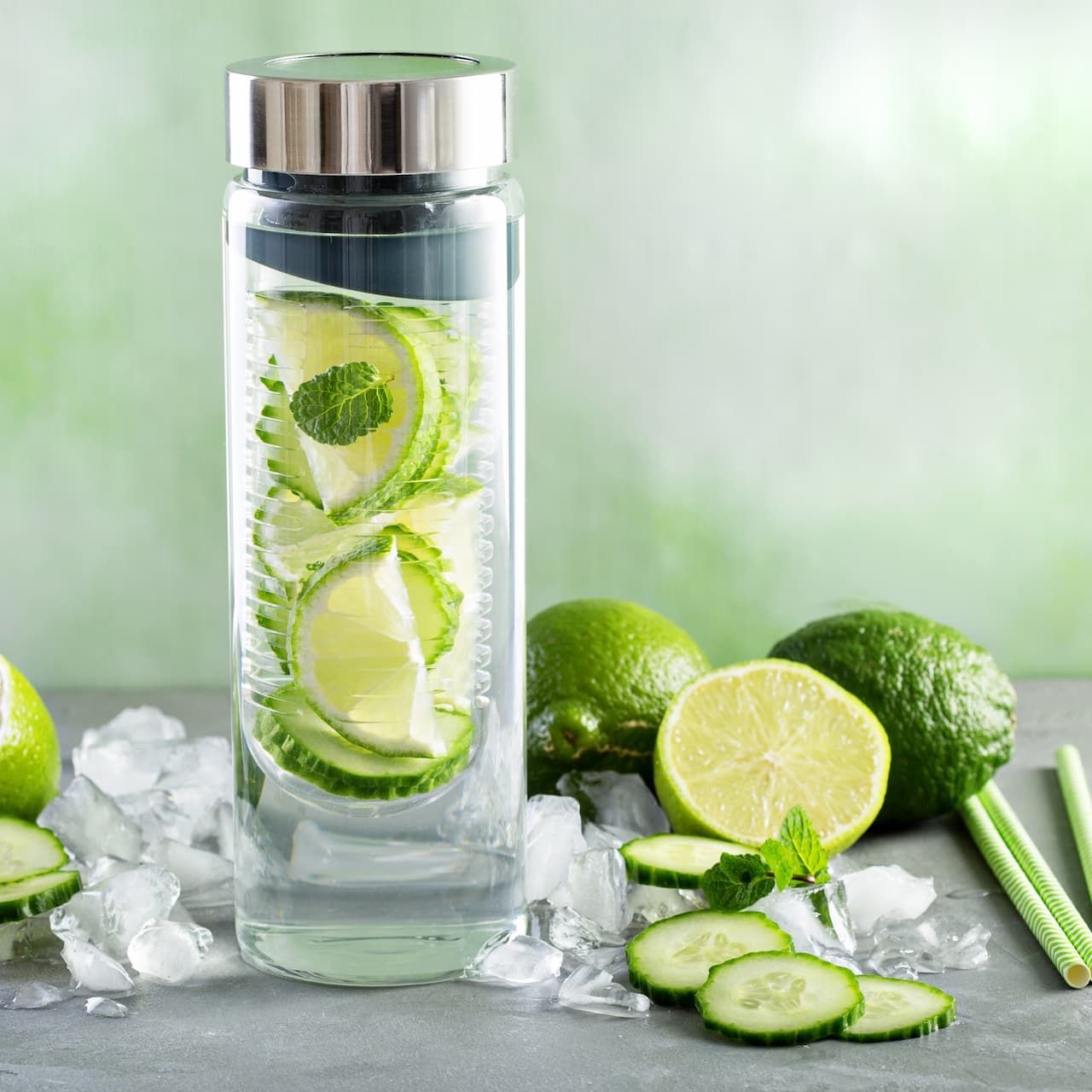 Une bouteille en verre remplie d'eau et de tranches de concombre sur de la glace.
