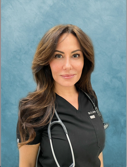 A woman wearing a black scrub top with a stethoscope around her neck