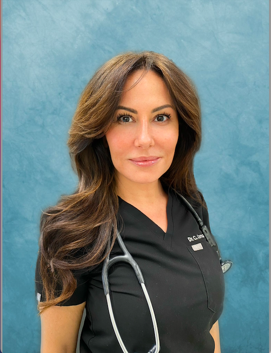 A woman wearing a black scrub top with a stethoscope around her neck