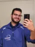 A man in a blue jacket taking a selfie with his phone