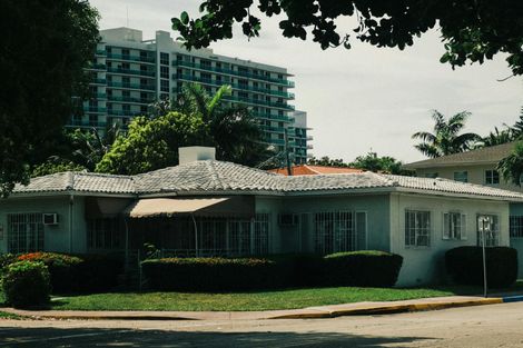 A white house with a large building in the background