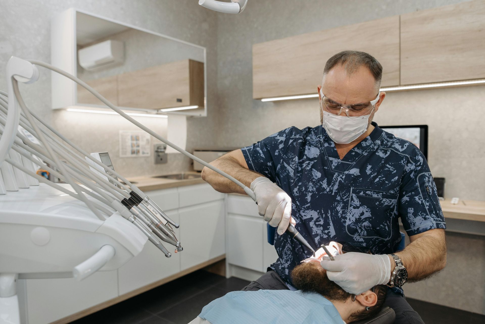 A dentist is examining a patient 's teeth in a dental office.