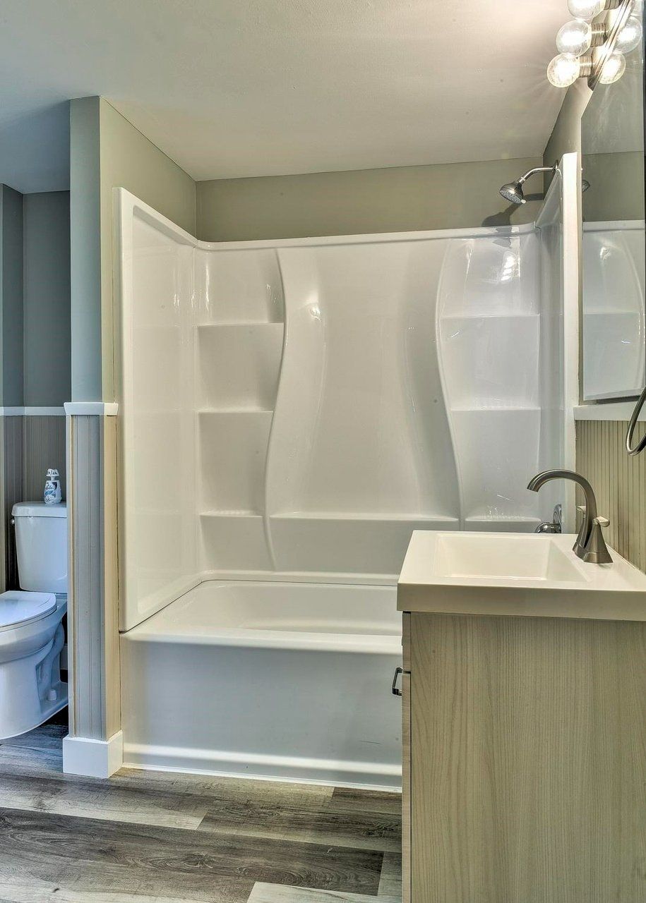 A bathroom with a tub a sink and a toilet