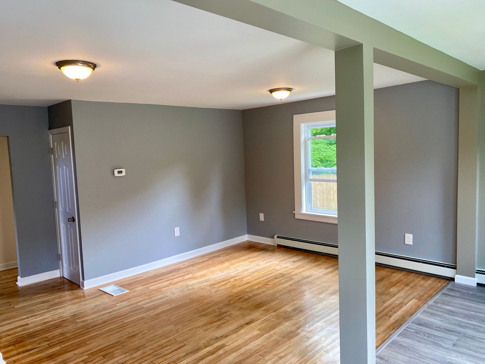 A living room with gray walls and wooden floors