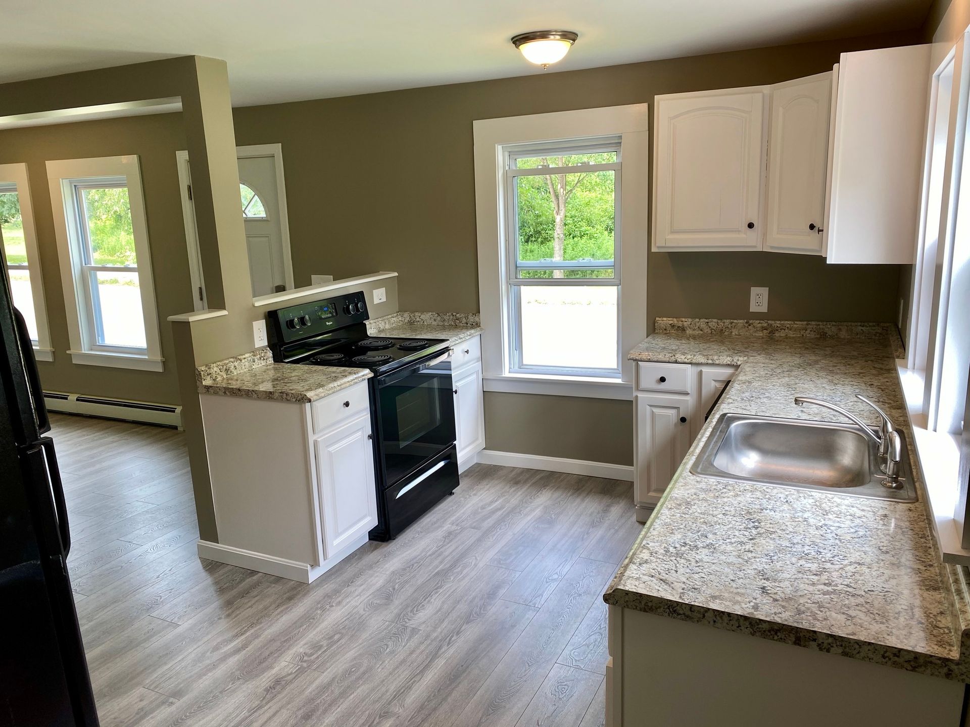 A kitchen with granite counter tops a stove and a sink