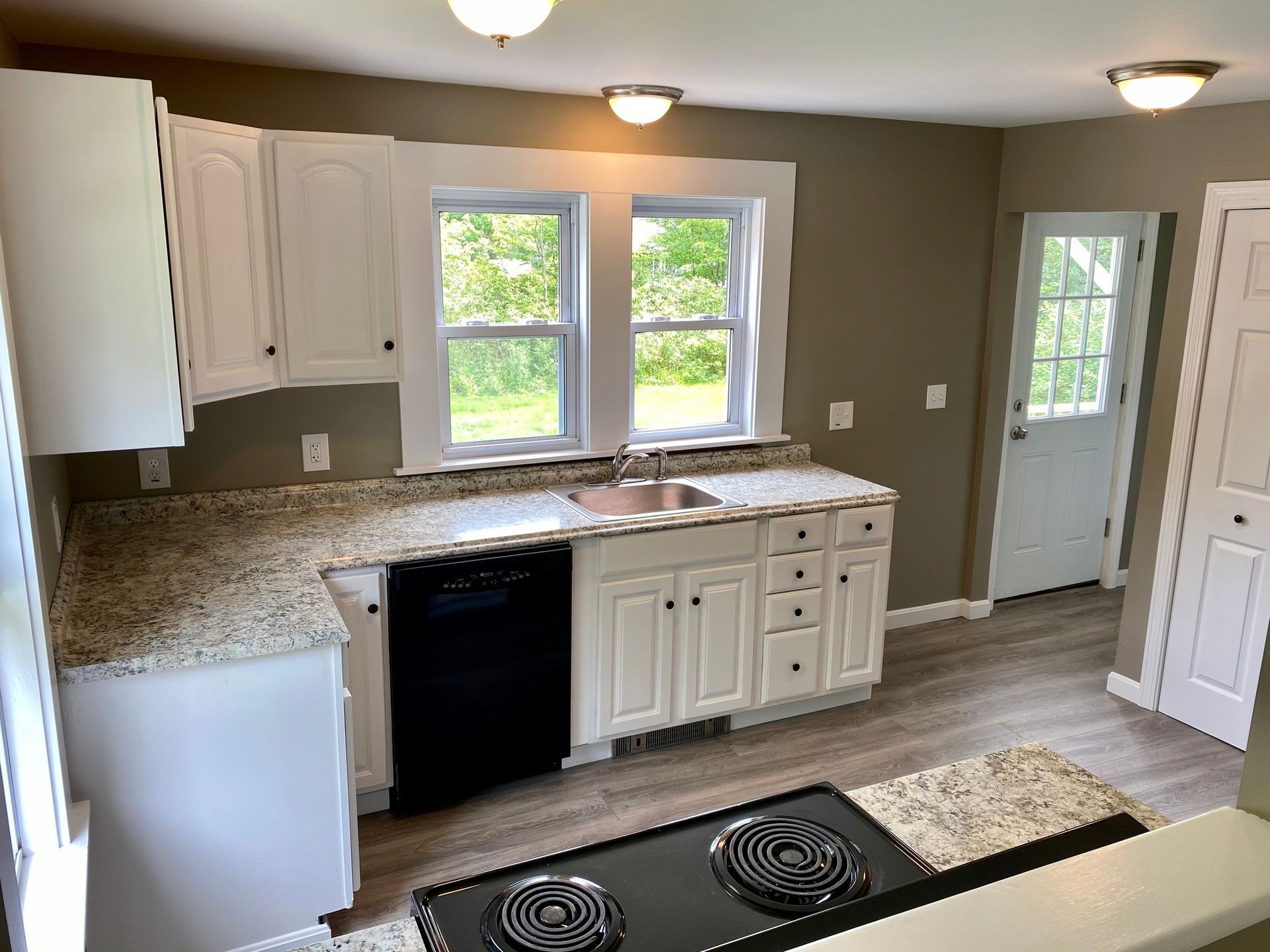 A kitchen with white cabinets and granite counter tops