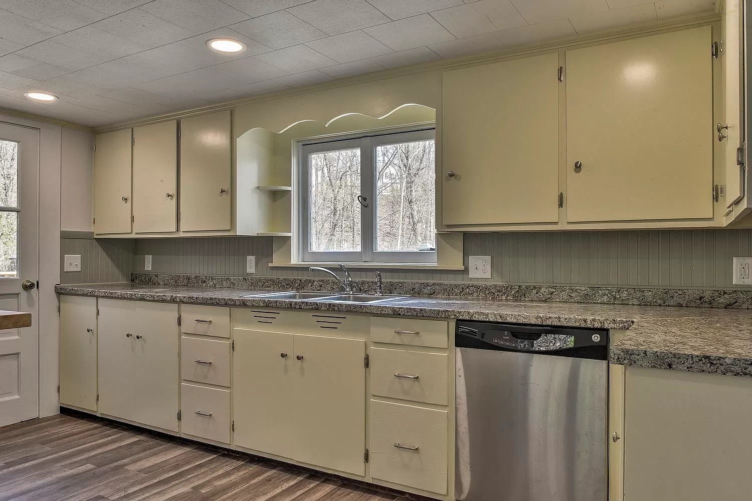 A kitchen with white cabinets and granite counter tops