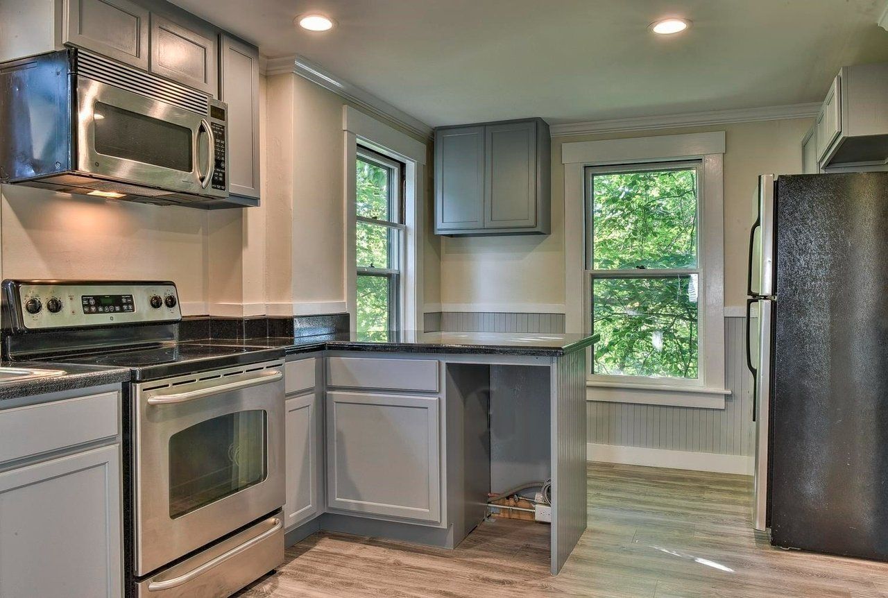 A kitchen with stainless steel appliances and a black refrigerator