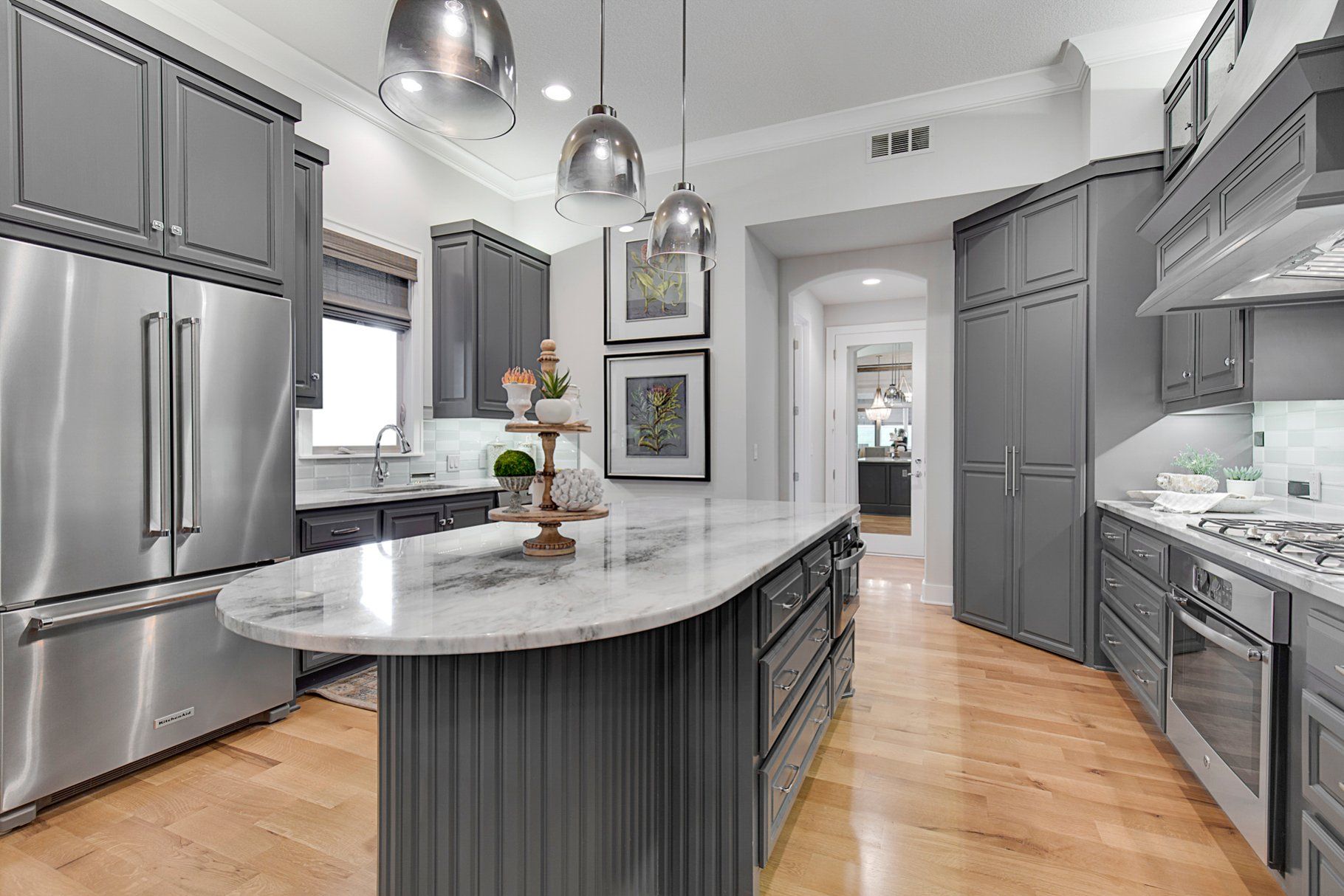 A kitchen with gray cabinets and stainless steel appliances