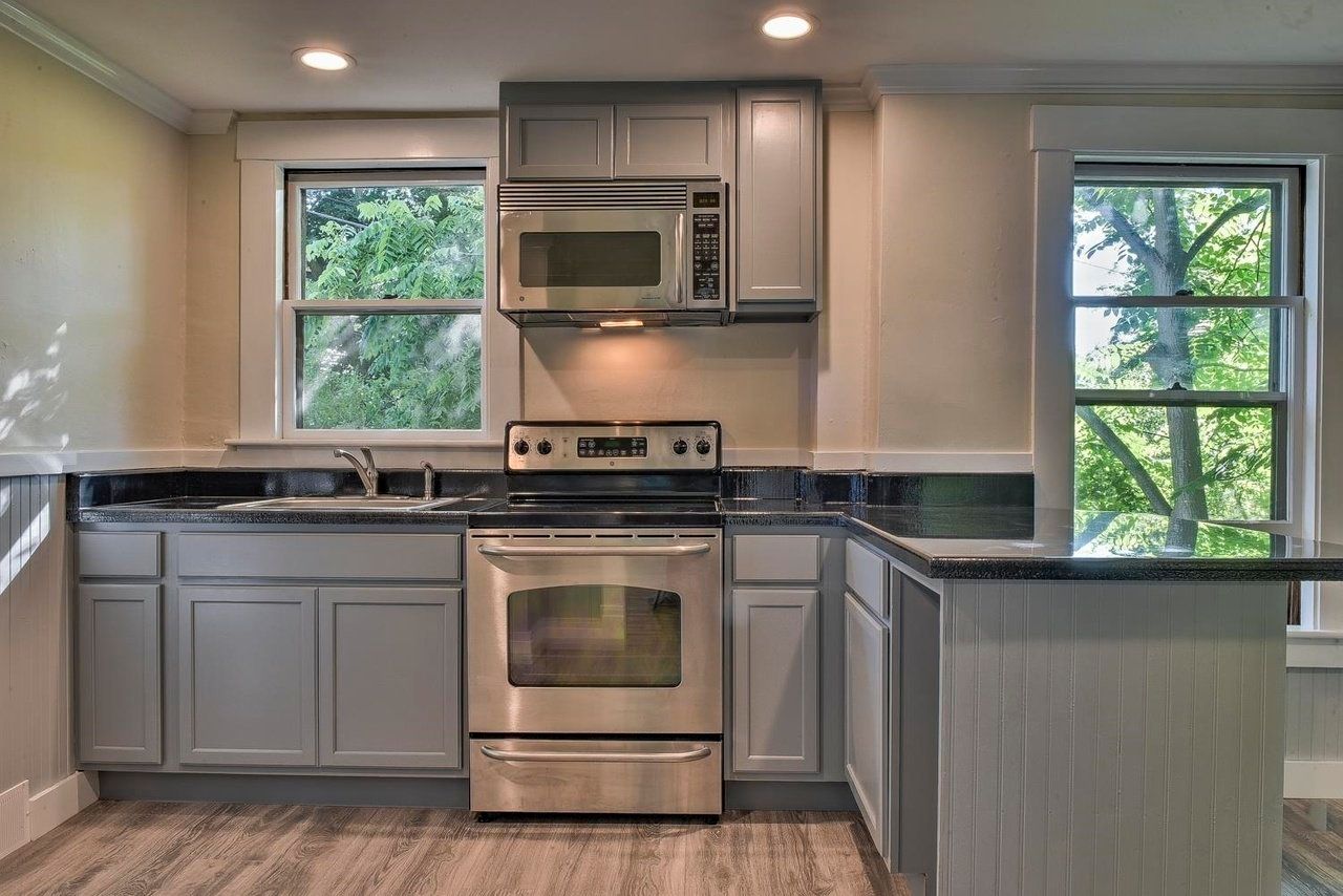 A kitchen with stainless steel appliances and gray cabinets