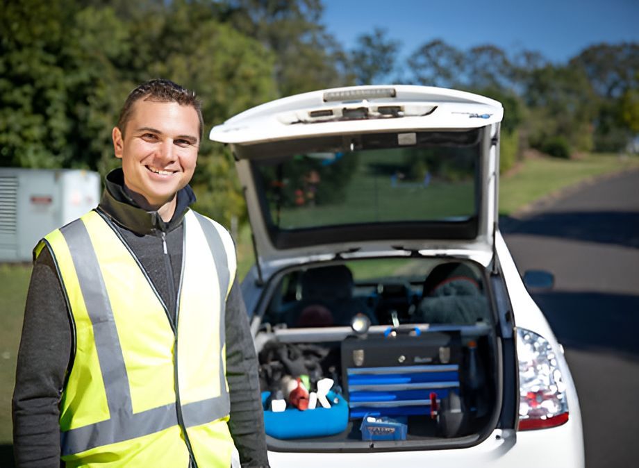 A Man in a Yellow Vest is Standing Next to a White Car — Unified Mechanical – Mobile Mechanic In Goonellabah, NSW