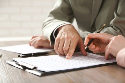 uomo che indica dove firmare su un documento