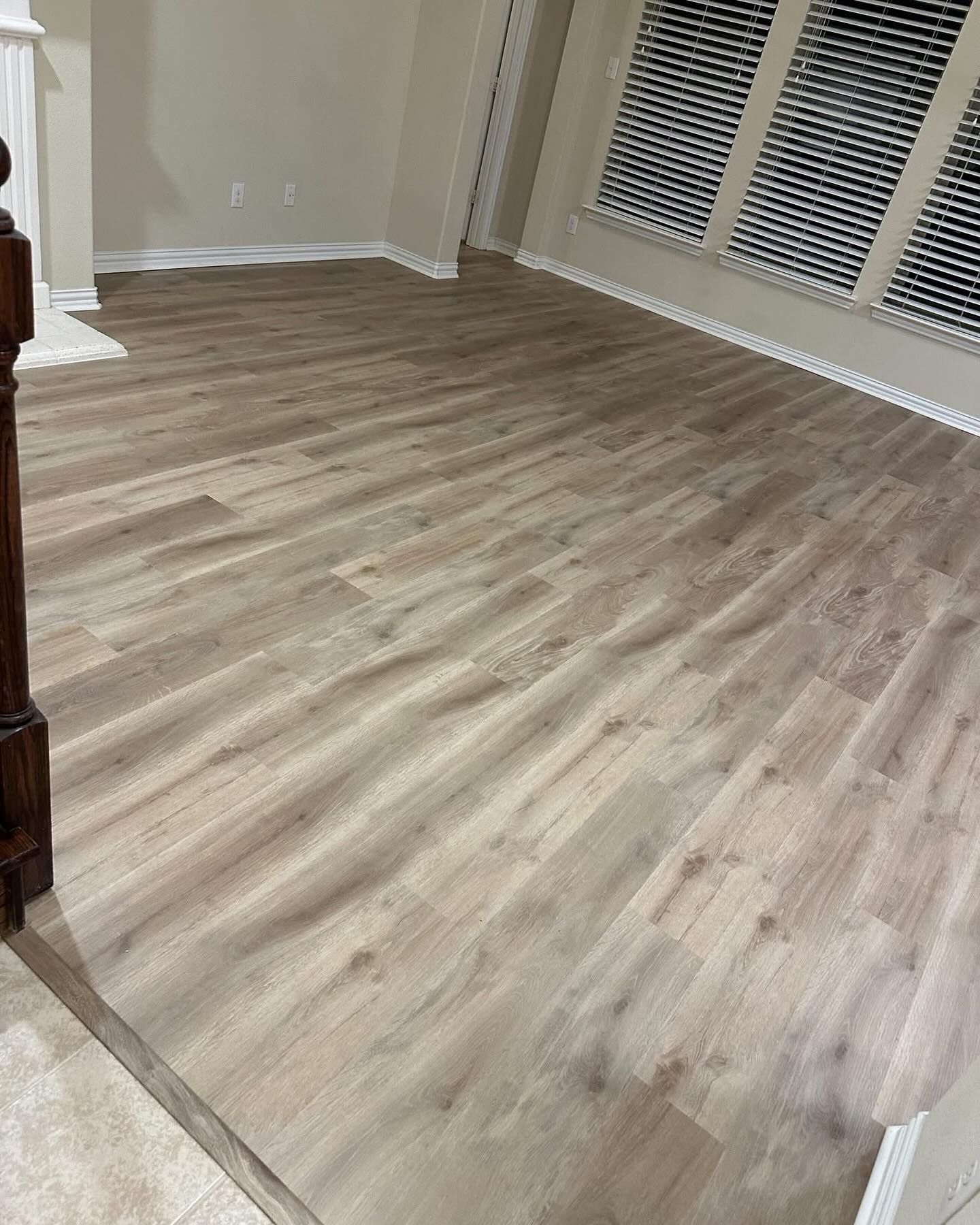 Light wood-look flooring installed in a room with large windows.