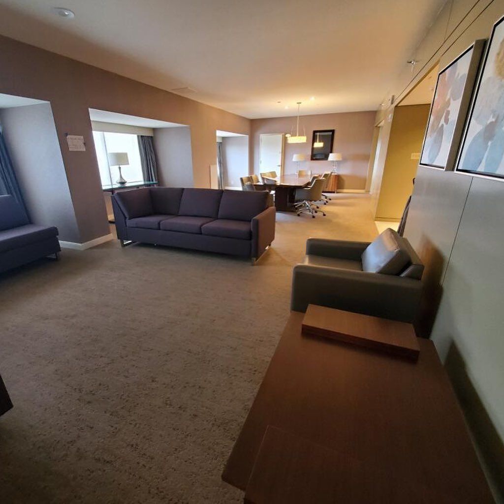Living room with gray sofa, chair, and dining area in the background.