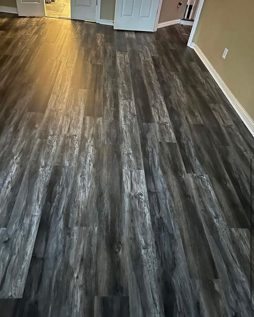 Dark grey wood-look flooring installed in a room, with visible grain and varying tones.