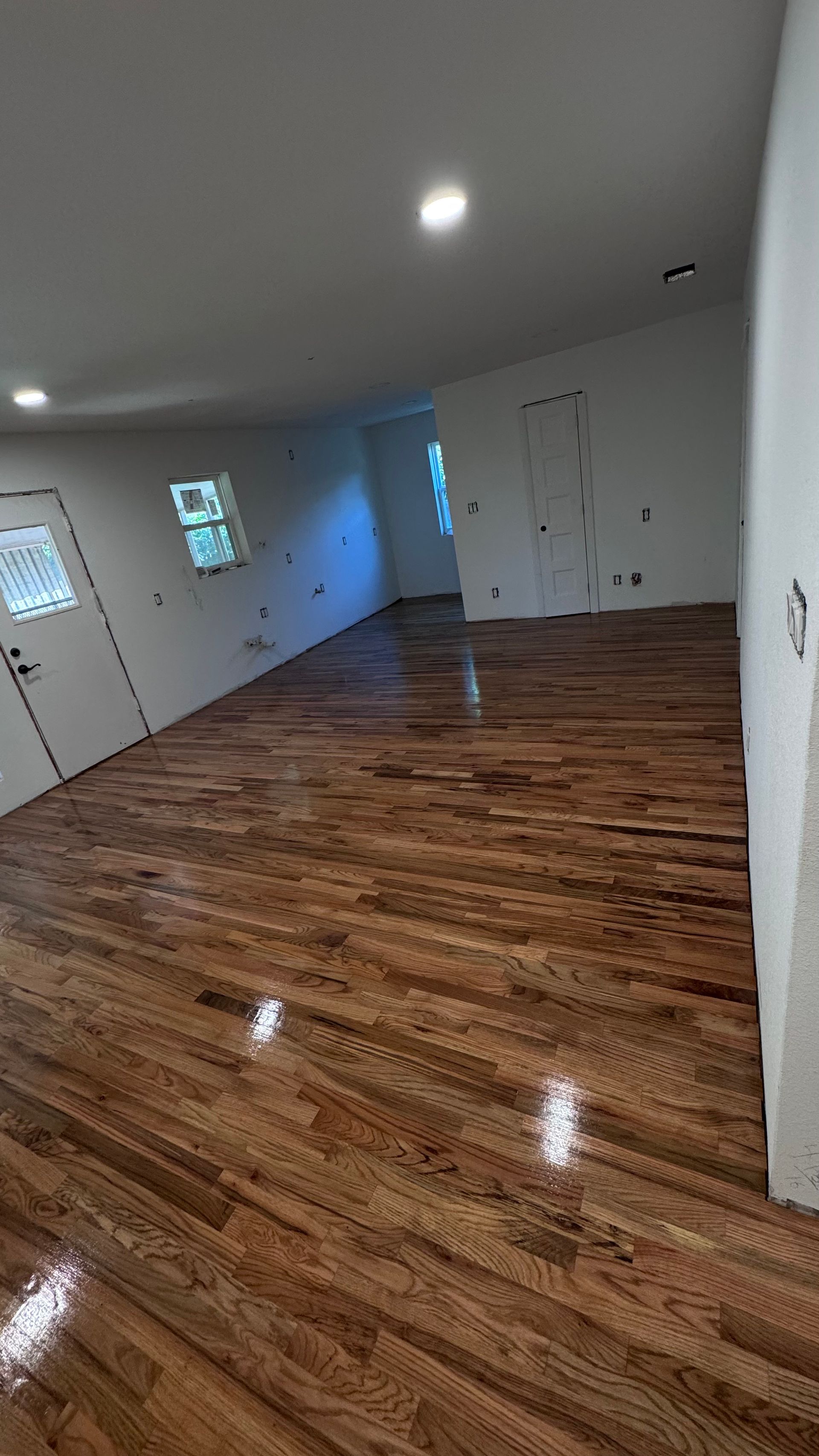 Wooden floor in a bright room with white walls and doors.