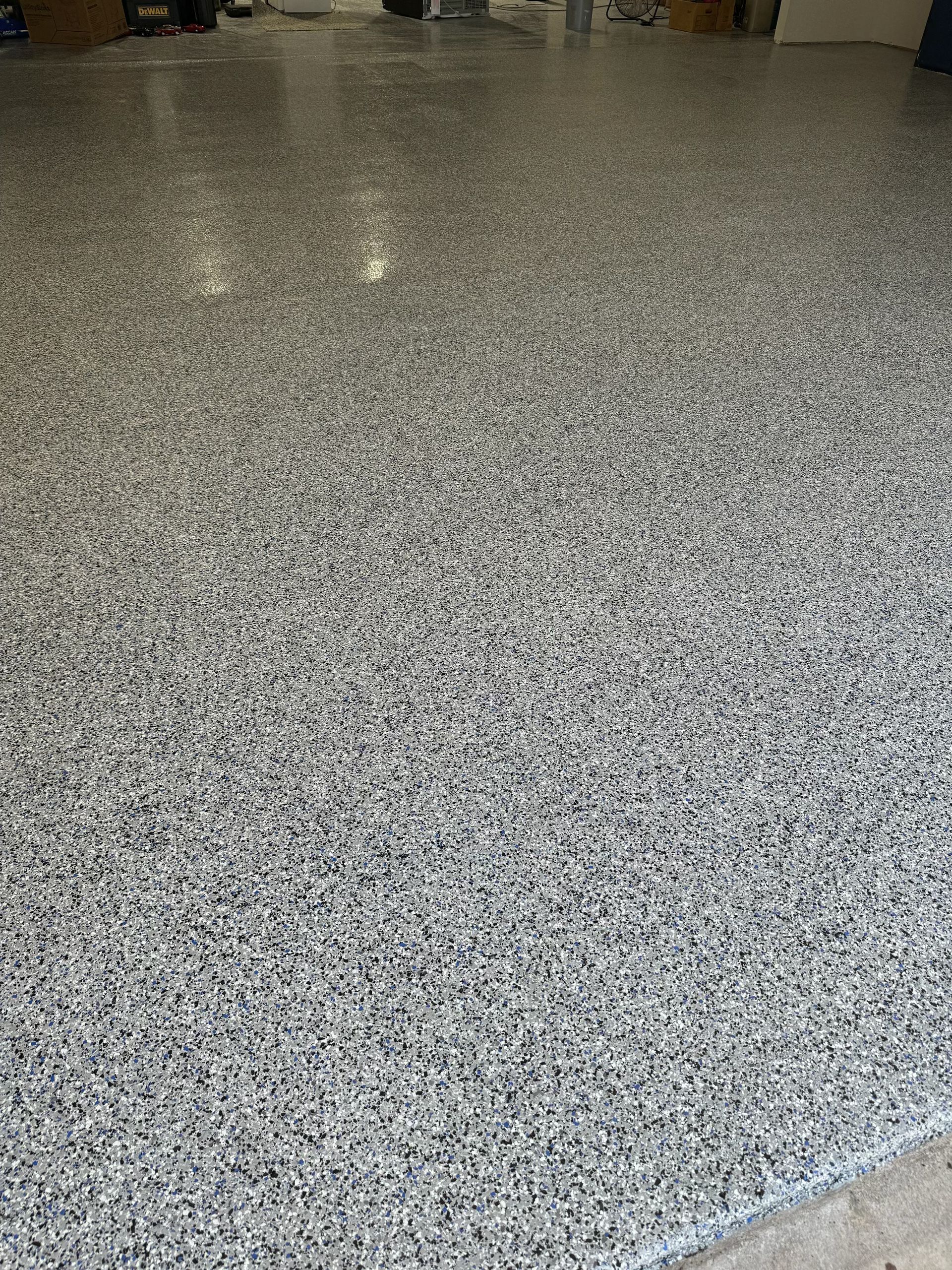 Granite-looking epoxy garage floor with a speckled pattern of gray and black chips.