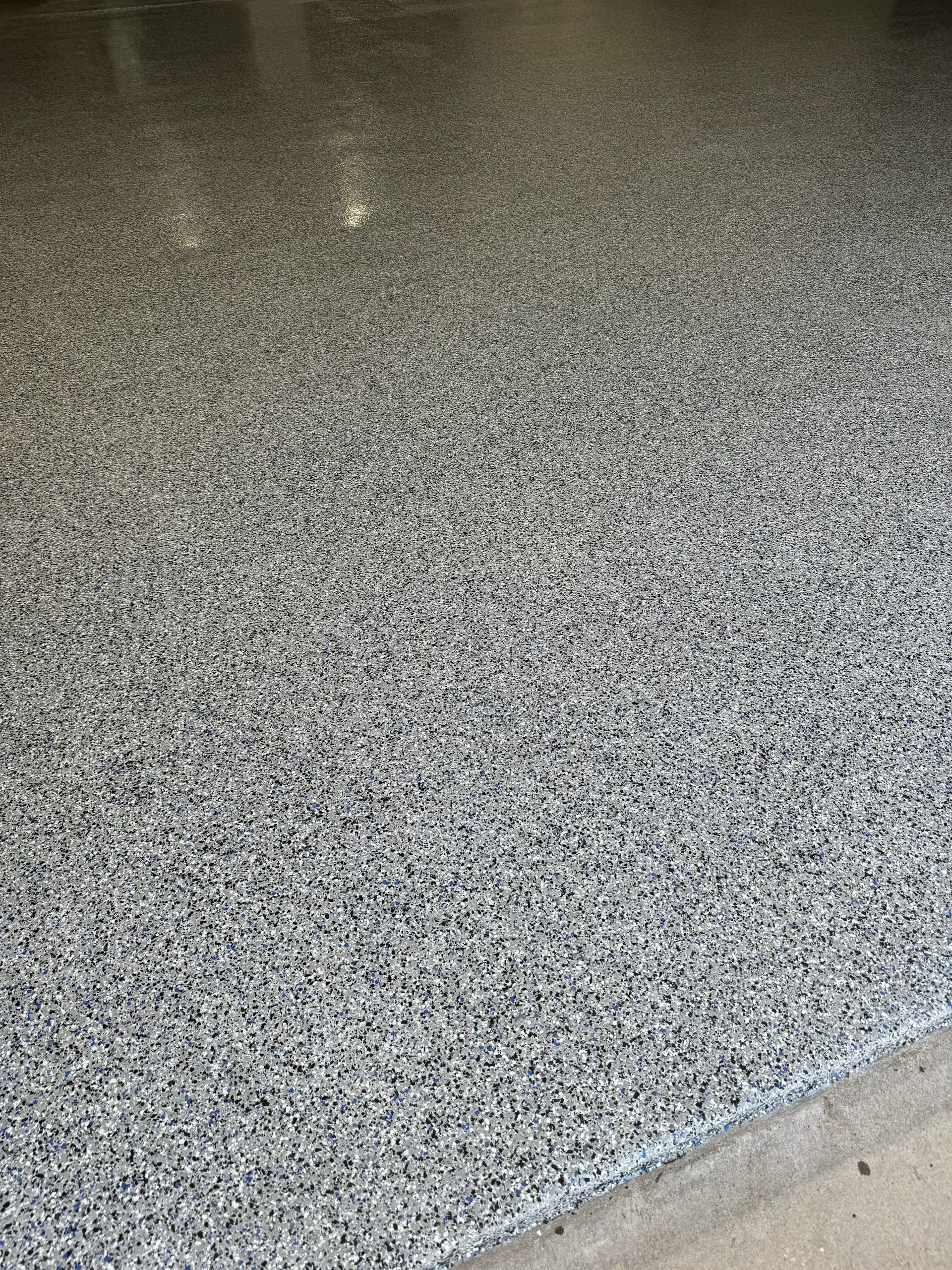 Gray speckled epoxy floor in a garage setting.