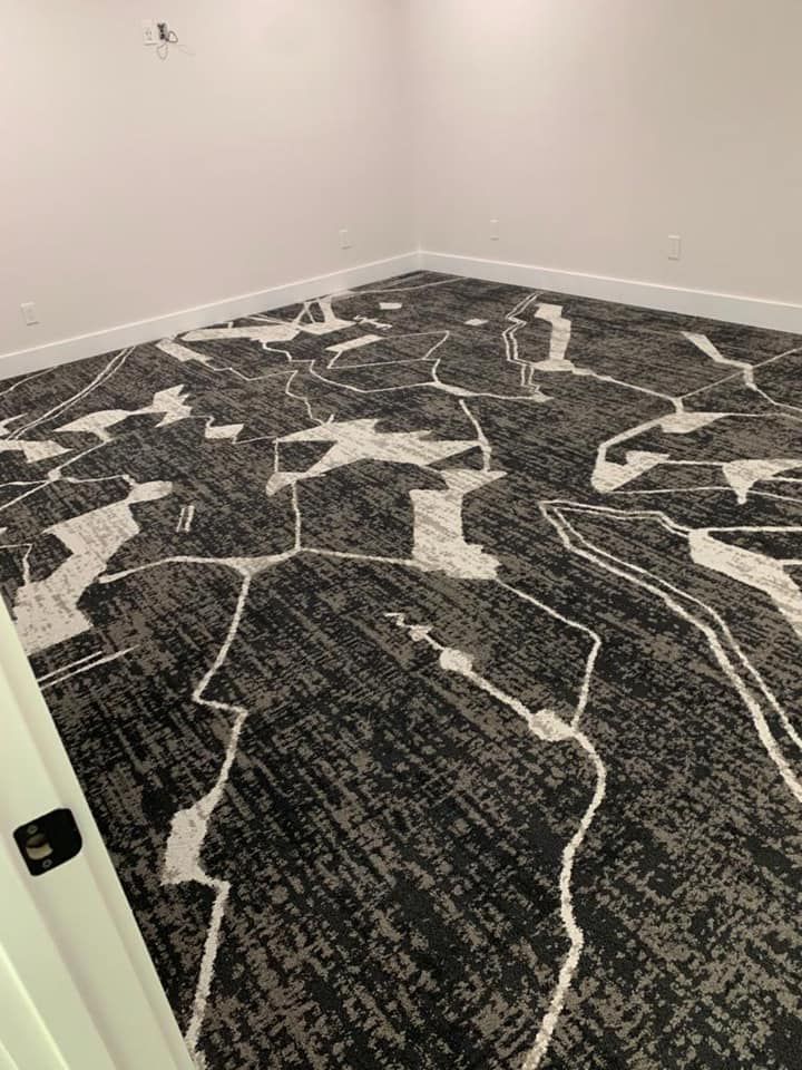 Room with abstract black and white patterned carpet, white walls, and door frame.