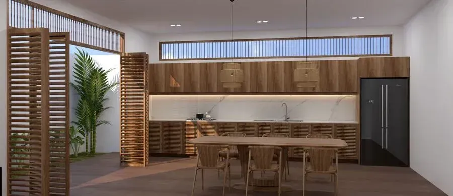 A modern kitchen with wooden cabinets and a dining table, open to a green outdoor space.
