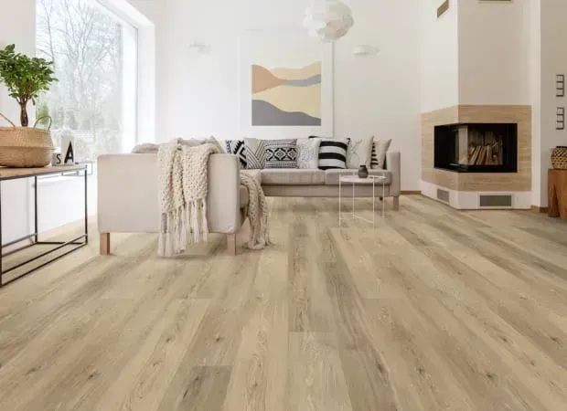 Bright living room with beige wood floors, couch, fireplace, and neutral décor.