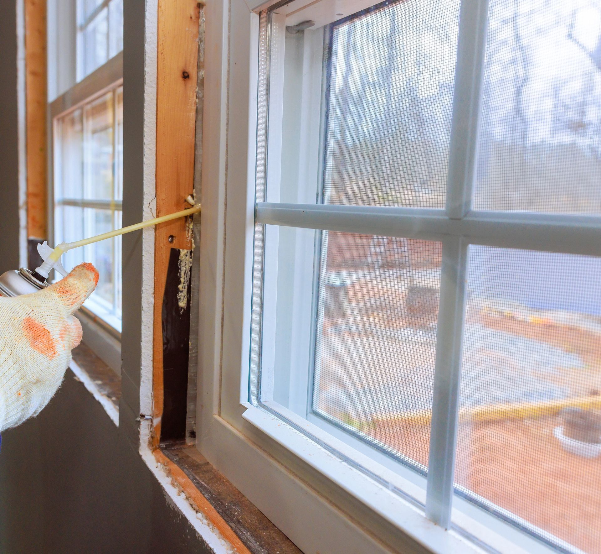 Expanding foam insulation applied around a window frame to seal air leaks and improve energy efficiency. Laramie, WY.