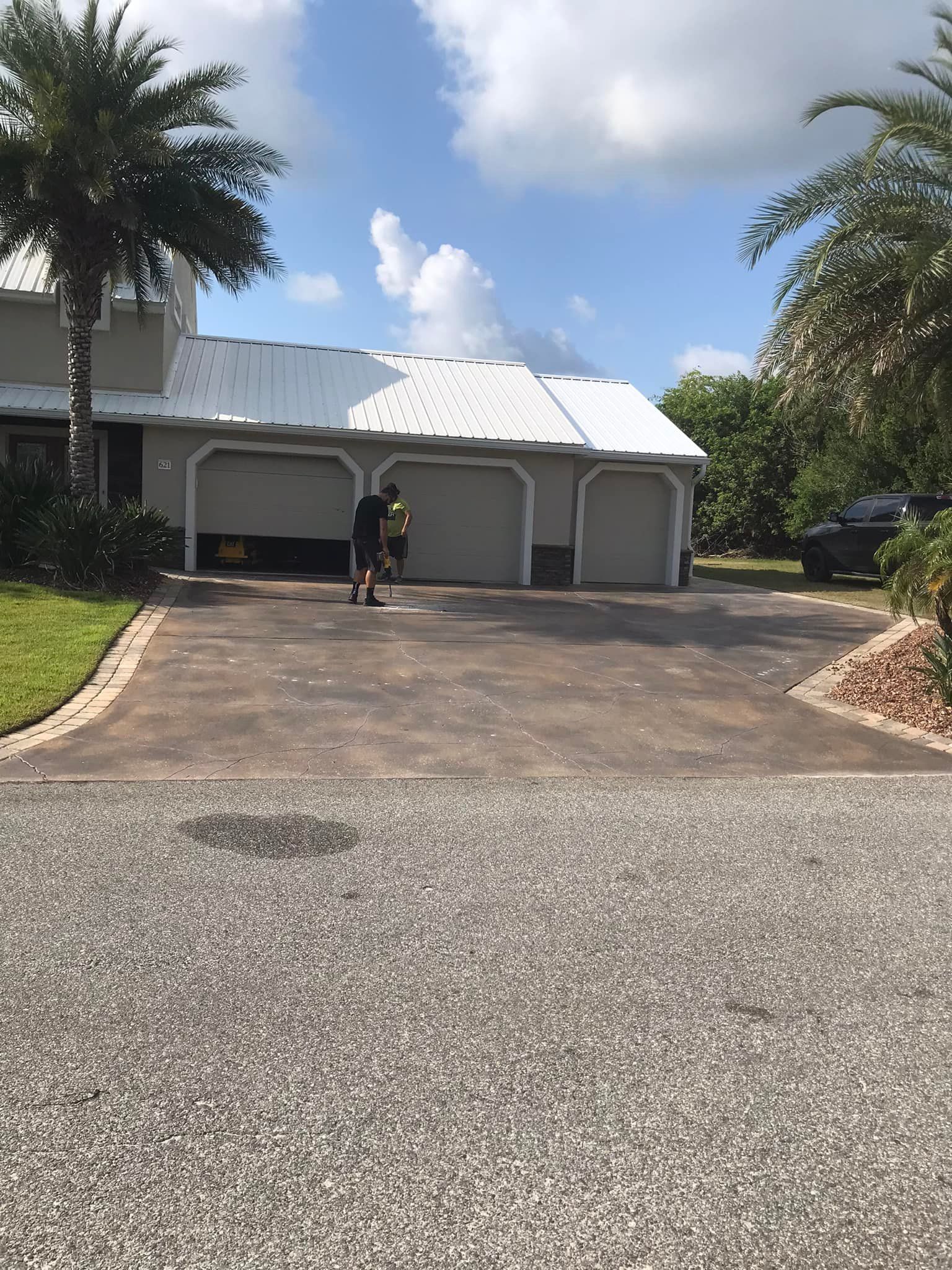 A man is standing in the driveway of a house.