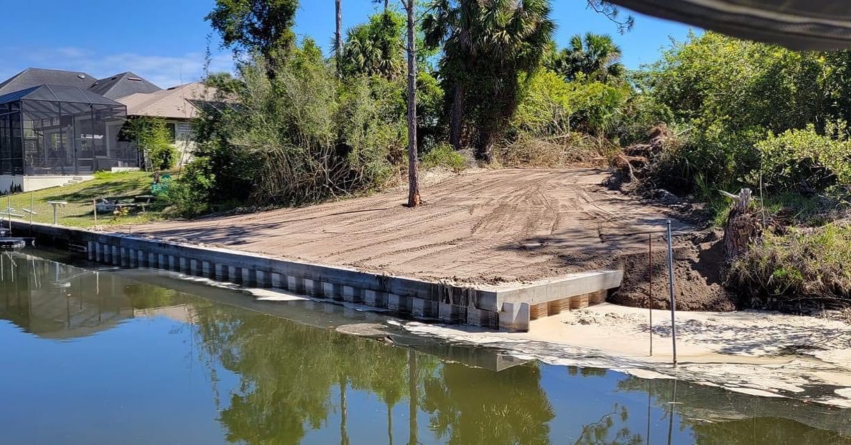 A large body of water surrounded by trees and a house.