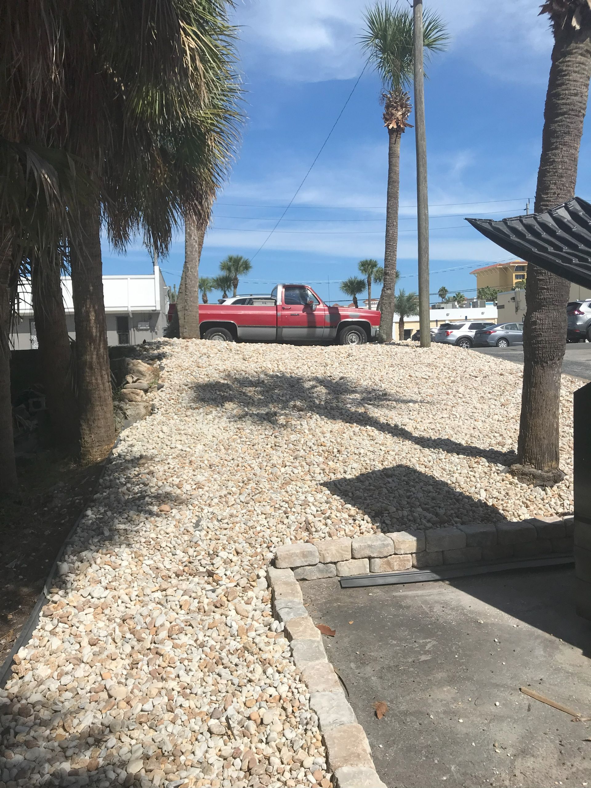 A red truck is parked on top of a pile of gravel