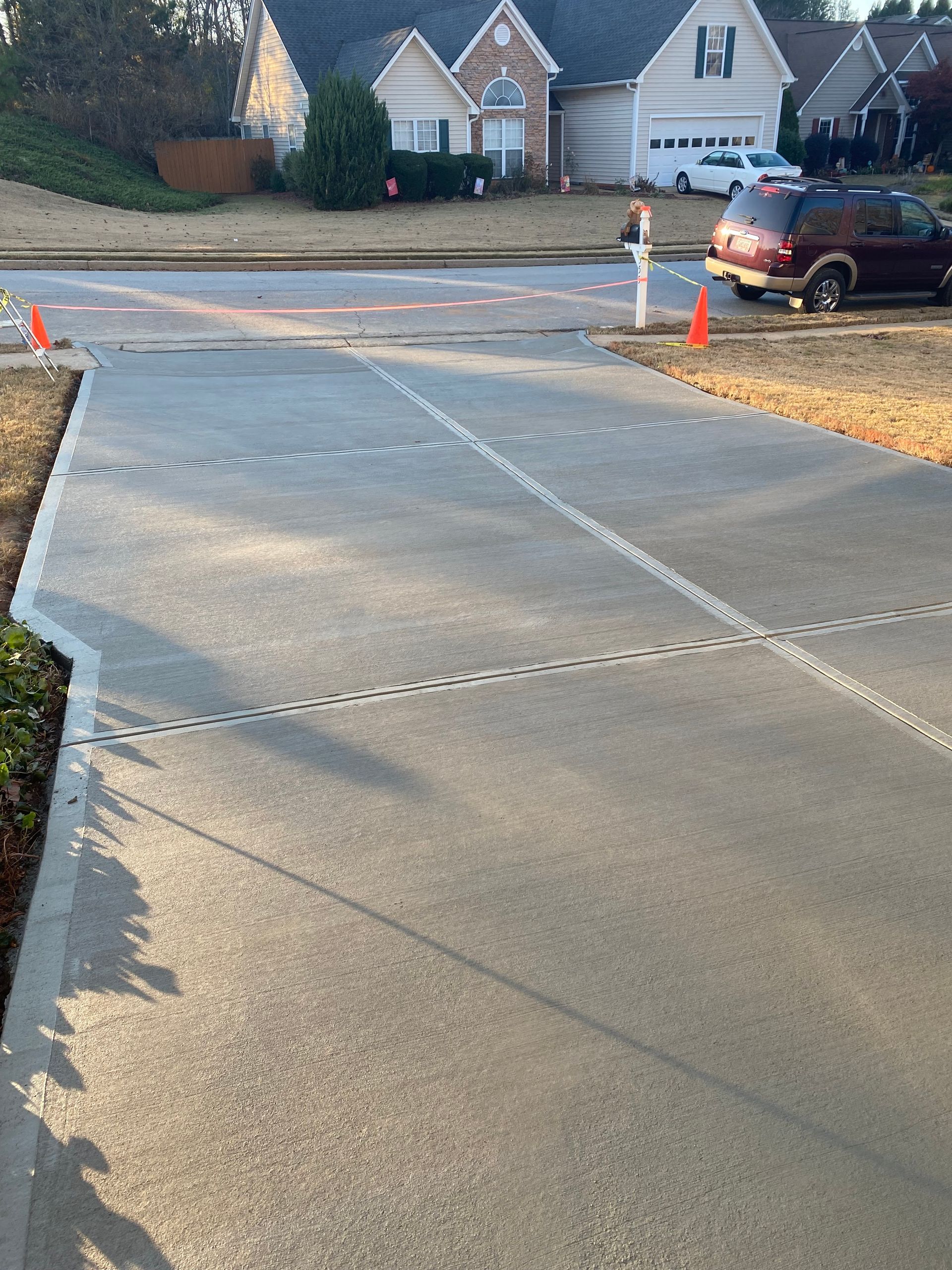 New concrete driveway with expansion joints in front of a house.