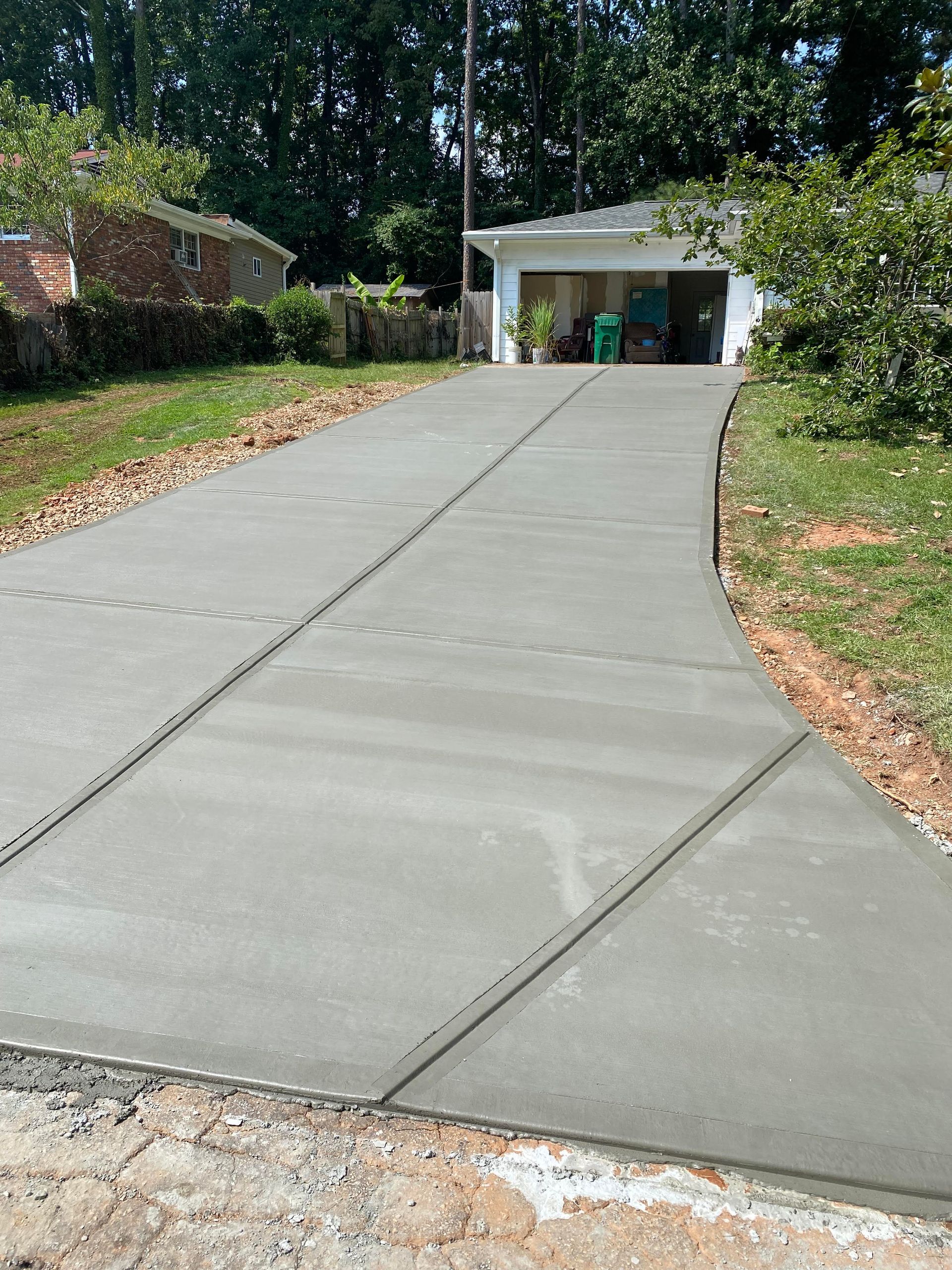 Newly poured concrete driveway leading to a garage.
