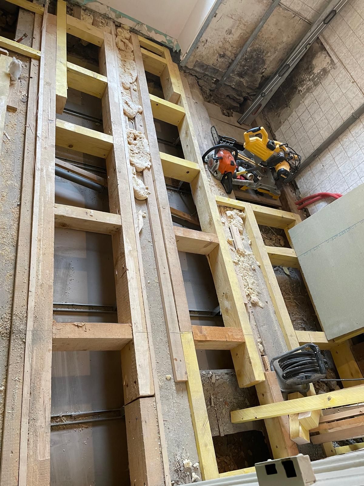 Une grande structure en bois est en cours de construction dans un bâtiment.