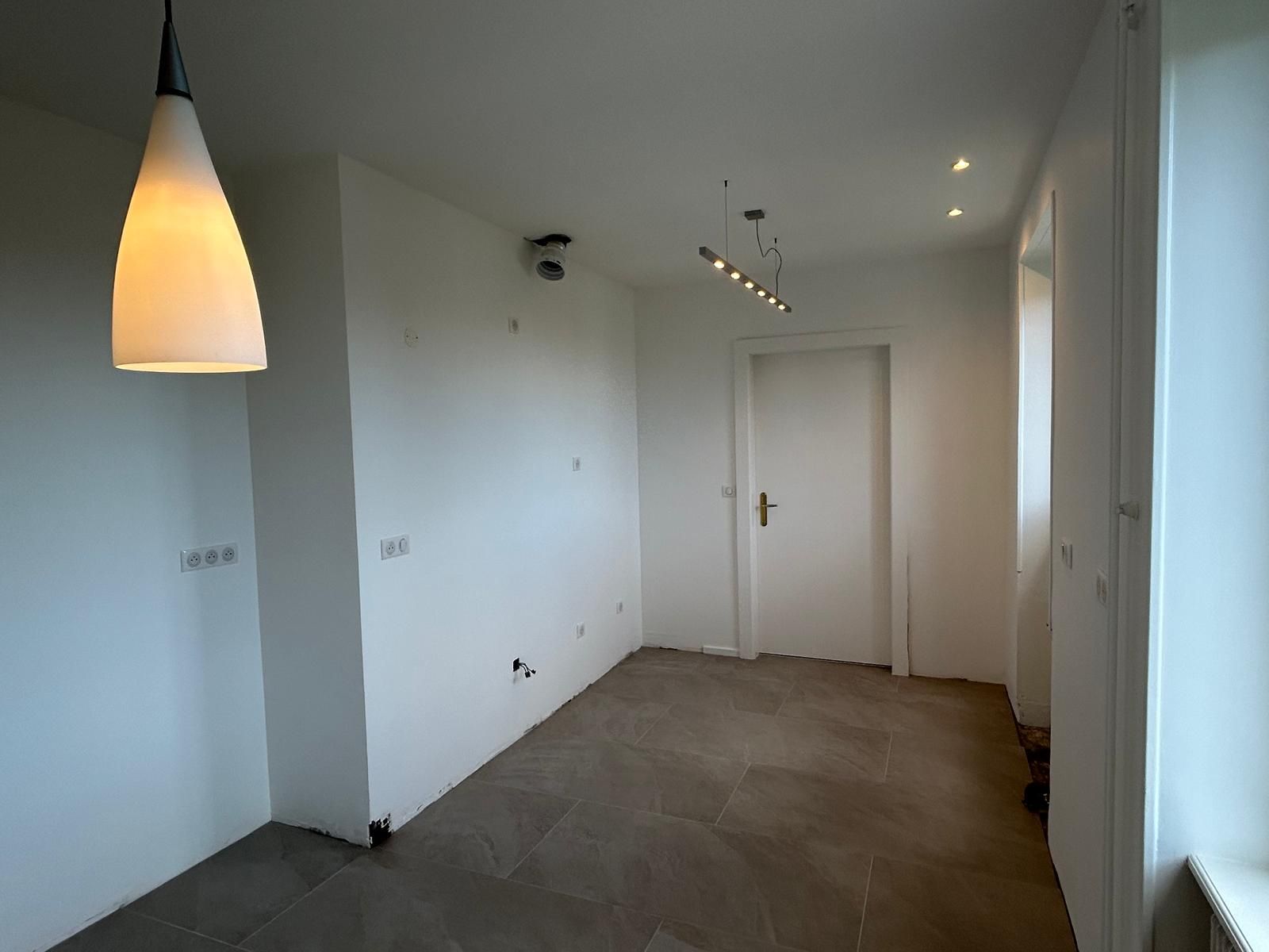 Une pièce vide avec une lumière suspendue au plafond