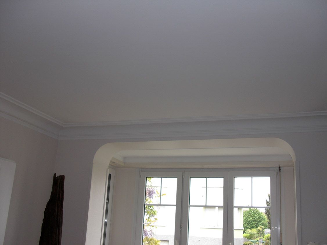 Une pièce avec une fenêtre et un plafond blanc