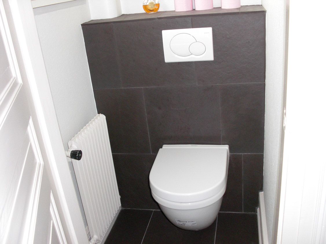 Une salle de bain avec toilettes et radiateur