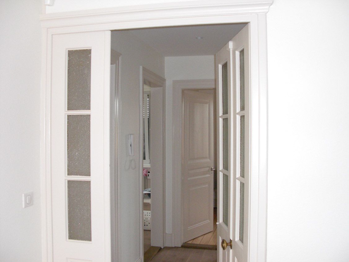 Un couloir avec une porte blanche ouverte