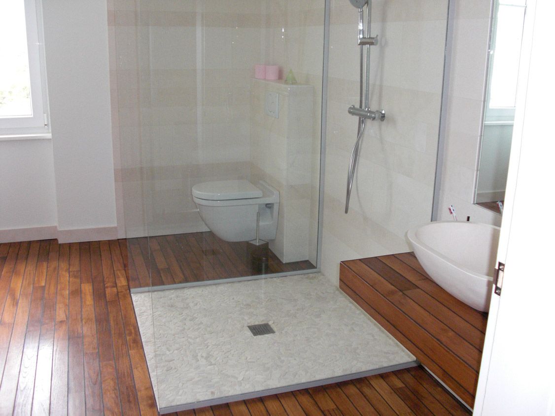 Une salle de bain avec douche à l'italienne, WC et lavabo.