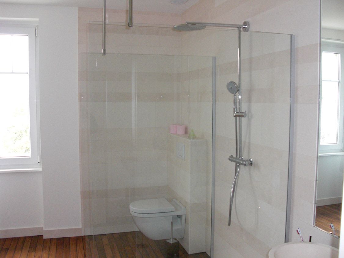 Une salle de bain avec WC, lavabo et cabine de douche.