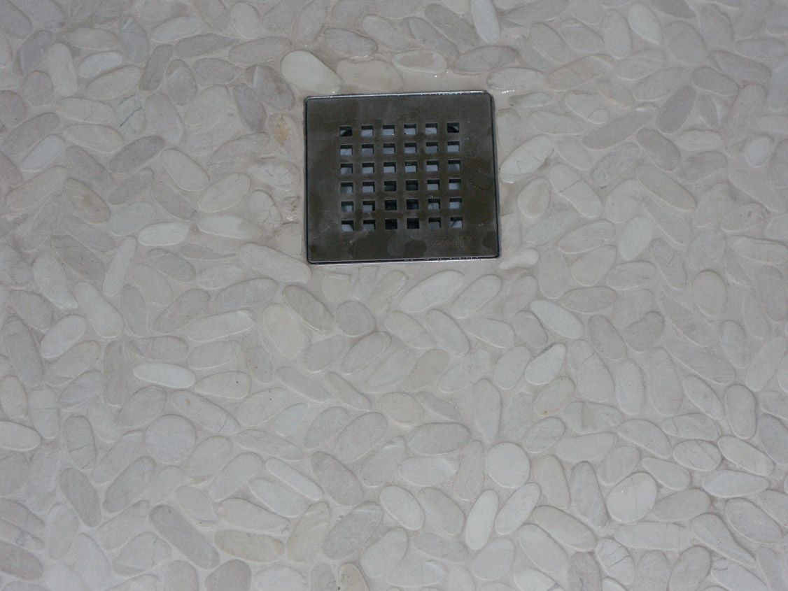 Un gros plan d'un drain sur un sol carrelé