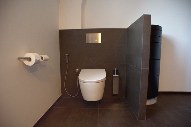 Une salle de bain avec toilettes et distributeur de savon